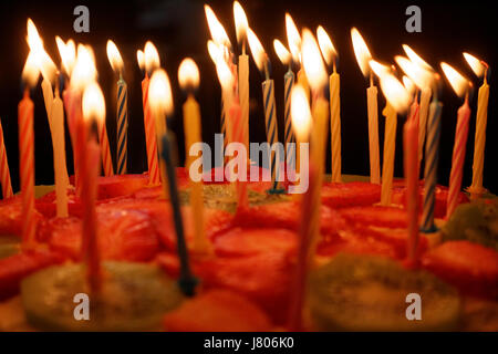 Gâteau d'anniversaire avec des bougies allumées sur un fond sombre Banque D'Images