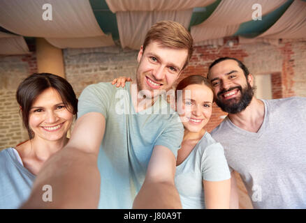 Happy friends au studio de yoga ou de sport en tenant selfies Banque D'Images