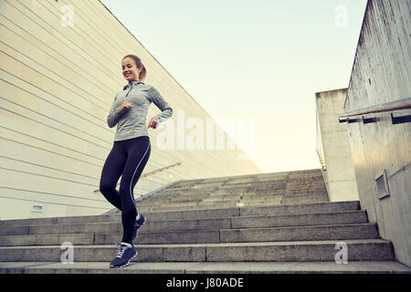 Happy sporty woman running au rez-de-ville Banque D'Images