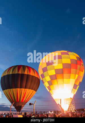 Un groupe de ballons à air chaud de partir au crépuscule Banque D'Images