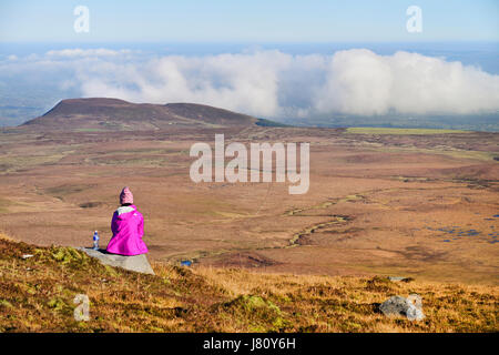 L'Irlande, le comté de Fermanagh, Cuilcagh Mountain Park, Randonneur admirant la vue depuis le sommet de la montagne Cuilcagh. Banque D'Images