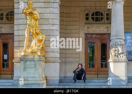 Femme assise à l'extérieur du Théâtre Dramatique Royal de Stockholm. Scène nationale de la Suède a été fondée en 1788 et le bâtiment actuel date de 1908 Banque D'Images