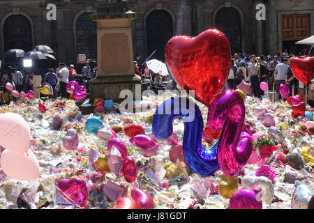 Une mer de ballons et tapis de fleurs St Anns carré comme pleureuses apporter hommages aux 22 victimes et la ville de Manchester a écrit sur le trottoir dans St Anns Square dans le centre-ville de Manchester en tant que personnes célèbrent et déposez un grief. Salman Abedi a fait exploser une bombe et est beleived pour faire partie d'une cellule terroriste à partir de la Libye. Banque D'Images