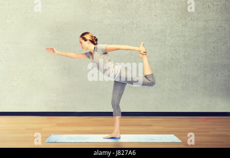 Femme faisant du yoga dans Lord of the dance posent sur mat Banque D'Images