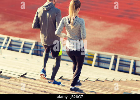 Couple running en bas sur stadium Banque D'Images