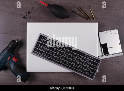 Ordinateur portable avec coponent et outil (concept de réparation) sur fond de table en bois Banque D'Images