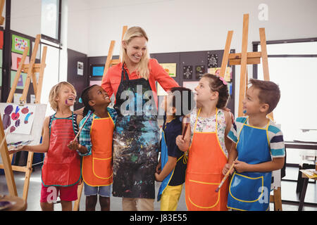 Enseignant et avoir schoolkids in classe de dessin Banque D'Images