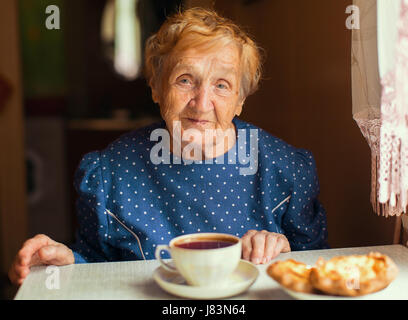 Femme âgée de boire du thé. Le russe ou l'ukrainien. Banque D'Images