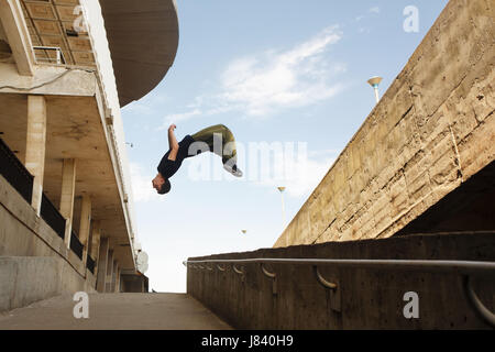 Un jeune homme fait un saut périlleux arrière. Parkour dans l'espace urbain. Sports dans la ville. L'activité sportive. Banque D'Images