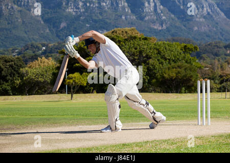 Toute la longueur de cricketer jouant sur terrain au cours de journée ensoleillée Banque D'Images