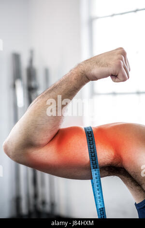 Digital composite de bras en surbrillance de l'homme la mesure de biceps avec ruban à mesurer Banque D'Images