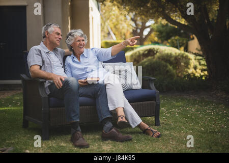 Happy senior couple sitting on couch in backyard Banque D'Images