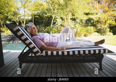 Toute la longueur de senior woman resting on lounge chair à portique Banque D'Images