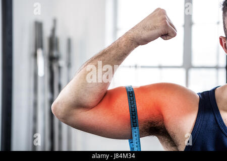 Digital composite de bras en surbrillance de l'homme la mesure de biceps avec ruban à mesurer Banque D'Images