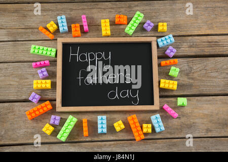 Vue aérienne de happy fathers day message sur l'ardoise par toy blocks at table Banque D'Images