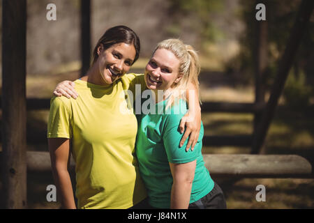 Portrait of happy friends with autour pendant un parcours dans boot camp Banque D'Images