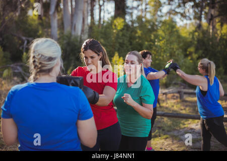 Woman practicing boxing dans le boot camp sur une journée ensoleillée Banque D'Images