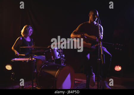 Chanteur avec le batteur de femmes dans la scène de nuit Banque D'Images