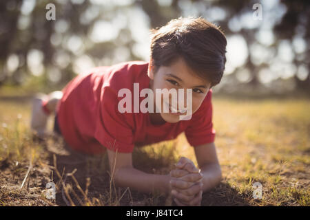 Portrait of happy kid d'effectuer l'exercice pendant les cours d'obstacle dans boot camp Banque D'Images