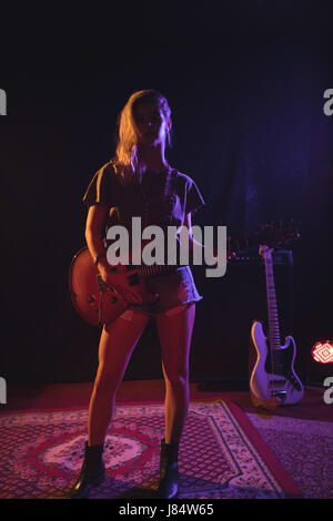 Portrait de femme avec guitare musicien standing in nightclub Banque D'Images