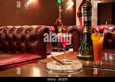 Des cocktails de fruits frais avec un narguilé et cigare sur la table Banque D'Images