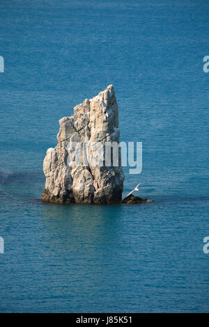 Lonely haut de rocher comme une voile dans une mer Banque D'Images