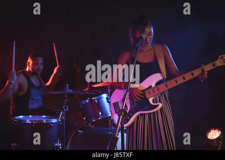 Chanteuse chanter alors que le batteur d'effectuer en boite Banque D'Images