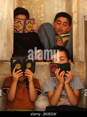 La ville de Gaza, bande de Gaza, territoire palestinien. 27 mai, 2017. Les enfants palestiniens lire exemplaires du Coran, livre saint de l'Islam, le premier jour du jeûne dans le mois du Ramadan, à la mosquée al-Omari, dans la ville de Gaza, le 27 mai 2017. Le Ramadan est sacré pour les musulmans parce que c'est pendant ce mois que selon la tradition, le Coran a été révélé au prophète Mohammed. Le jeûne est l'une des cinq principales obligations religieuses sous l'Islam. Plus de 1. Banque D'Images