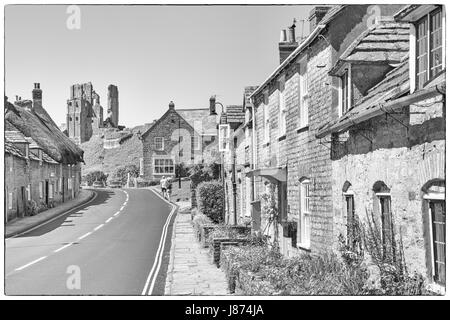 Route à travers le château de Corfe village avec vue sur le château de Corfe Castle, Dorset UK en Mai - noir et blanc monochrome N&B Banque D'Images