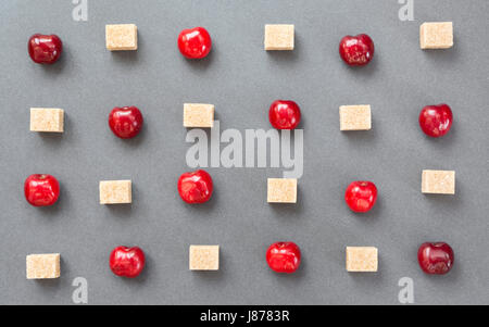 Les cerises et le sucre en cubes. Fond d'été doux. Vue d'en haut Banque D'Images