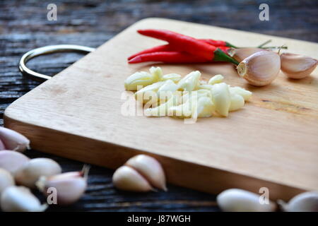 Épices piment et l'ail mettre sur planche à découper en bois sur la table en bois. Banque D'Images