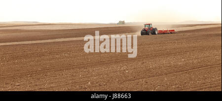 Un printemps image d'un tracteur laboure dans le champs agricoles fertiles de l'Idaho. Banque D'Images