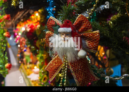 Santa Claus est perché sur l'arbre de Noël illuminé à Kakrail à Dhaka le Église la veille de Noël. Dhaka, Bangladesh Banque D'Images