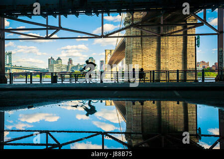 Reflet de l'eau des cyclistes et pont de Brooklyn à New York City Banque D'Images