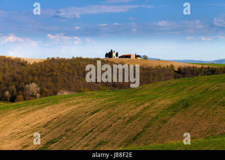 Beau paysage toscan avec une ferme isolée dans les champs au coucher du soleil Banque D'Images