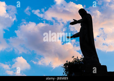 Silhouette de la Vierge Marie, au coucher du soleil. Contexte adapté à différents concepts religieux et spirituels. Banque D'Images