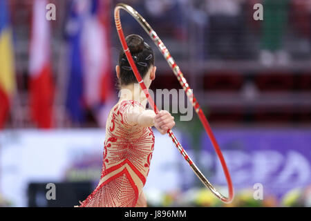 Chaque athlète de gymnastique rythmique joue avec hoop sur l'arène. Les gens méconnaissables. Banque D'Images