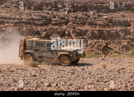 Un soldat italien attribué à 3e compagnie, Reggimento Lagunari court vers un objectif alors qu'un véhicule blindé durs vers un support à proximité-par-feu poste à un squad live-le-feu le 11 mai à Wadi Shadiya, la Jordanie dans le cadre de l'exercice 2017 lion avide. Désireux Lion a été un exercice multinational d'une semaine avec le Royaume hachémite de Jordanie, afin d'échanger de l'expertise militaire et améliorer l'interopérabilité entre les pays partenaires. (U.S. Photo de l'armée par le sergent. Leah R. Kilpatrick, 3e Brigade blindée du Bureau des affaires publiques de l'équipe de combat, 1re Division de cavalerie (publié) Banque D'Images