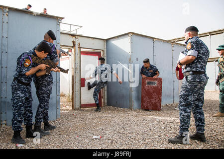 Un membre des forces de sécurité irakiennes kicks ouvrir une porte pendant un entraînement en zone urbaine chargé par Guardia Civil espagnole formateurs à la gamme Besmaya complexe, l'Iraq, le 15 mai 2017. Cette formation fait partie de la Force opérationnelle interarmées combinée globale - Fonctionnement résoudre inhérent à renforcer les capacités des partenaires mission par la formation et de l'amélioration de la capacité des forces des combats en partenariat avec ISIS. Les GFIM-OIR est la Coalition mondiale pour vaincre ISIS en Iraq et en Syrie. (U.S. Photo de l'armée par le Cpl. Tracy McKithern) Banque D'Images