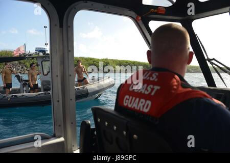 L'équipage de la station de la Garde côtière canadienne Apra Harbour à bord d'un 29 pieds de Boat-Small Réponse parler avec les membres de l'unité mobile de destruction de la Marine cinq avant qu'une détonation sous l'exercice dans l'Apra Harbour, de Guam, le 18 mai 2017. Membres de la gare d'Apra Harbour patrouillé dans le périmètre de la zone de sécurité au cours de l'évolution pour assurer la sécurité du public et des participants à l'exercice. (U.S. Photo de la Garde côtière du Maître de 2e classe Melissa E. McKenzie/libérés) Banque D'Images