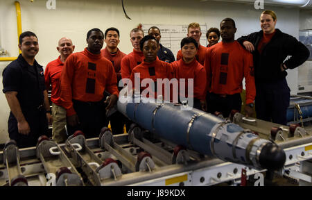 170521-N-WS952-028 LES EAUX SITUÉES AU SUD DU JAPON (21 mai 2017) marins prendre une photo de groupe avec une GBU-54 missile dans le magazine du navire à la suite d'une équipe de formation mobile explosées (MOTT) exercer à bord de la Marine a l'avant-déployé, porte-avions USS Ronald Reagan (CVN 76). Formation ordnancemen MOTT aviation apprend comment manipuler en toute sécurité, assembler, démonter, tester et stow explosés. Ronald Reagan, le groupe aéronaval du porte-étendard de 5, fournit une force prête au combat qui protège et défend les intérêts de maritime collective de ses alliés et partenaires dans la région du Pacifique-Indo-Asia. (U.S. Phot de la marine Banque D'Images