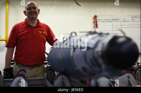 170521-N-WS952-032 LES EAUX SITUÉES AU SUD DU JAPON (21 mai 2017) Bob Kline, analyste logistique pour le commandant, Naval Air Force's Mobile explosées Training Team (MOTT), pose pour une photo avec une GBU-54 missile dans un casier de munitions de la marine à bord des porte-avions déployés, l'USS Ronald Reagan (CVN 76). Formation ordnancemen MOTT aviation apprend comment manipuler en toute sécurité, assembler, démonter, tester et stow explosés. Ronald Reagan, le groupe aéronaval du porte-étendard de 5, fournit une force prête au combat qui protège et défend les intérêts de maritime collective de ses alliés et partenaires de l'Indo-Asia Banque D'Images