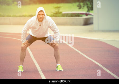 Jeune athlète se préparer pour l'exercices du matin sur la piste de course. Scène urbaine. Sport, entraînement, mode de vie sain, les concepts de remise en forme. Banque D'Images