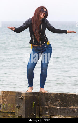 Bournemouth, Dorset, UK. 28 mai, 2017. UK : Météo des plages de Bournemouth à temps couvert, mais le soleil essaie de percer. Les visiteurs vers le bord de la tête pour tirer le meilleur de la Banque week-end de vacances. Woman balancing sur épi, souriant. Credit : Carolyn Jenkins/Alamy Live News Banque D'Images