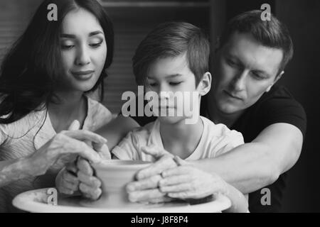 Travail Famille poterie sur roue. Mère et père à enseigner à leurs fils à sculpter ou faire clay pot Banque D'Images