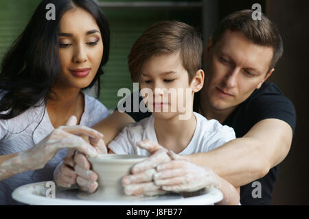 Travail Famille poterie sur roue. Mère et père à enseigner à leurs fils à scupl ou faire clay pot Banque D'Images