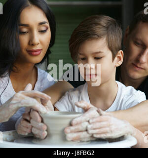 Travail Famille poterie sur roue. Mère et père à enseigner à leurs fils à scupl ou faire clay pot Banque D'Images