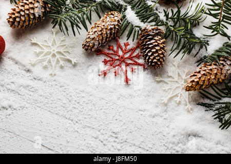 Snowy christmas background avec des cônes de pin et de branches de sapin. Banque D'Images