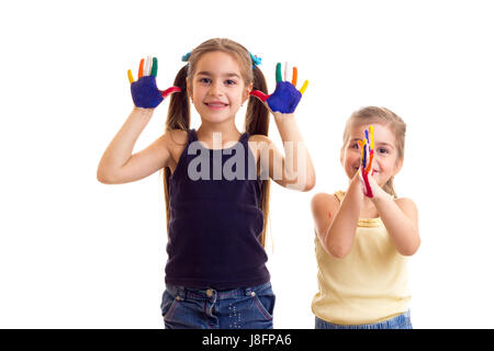 Deux petites filles optimistes en noir et jaune avec des chemises de couleur et queues de mains sur fond blanc en studio Banque D'Images