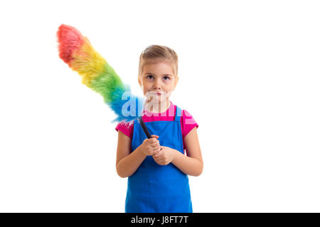 Triste petite fille avec queue de porter en chemise rose et bleu tablier avec duster colorés sur fond blanc en studio Banque D'Images